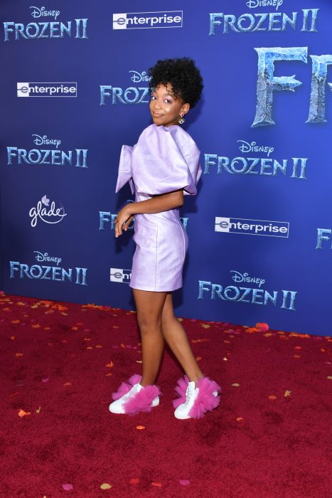 Eris braker posando con un vestido morado y tenis peculiares durante la alfombra roja de frozen 2