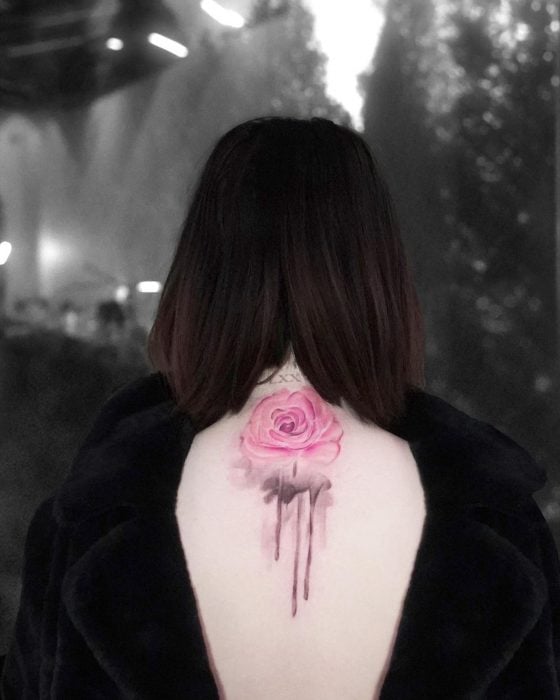 Tatuaje de una rosa con tallo negro en acuarela sobre la espalda de Selena Gomez 