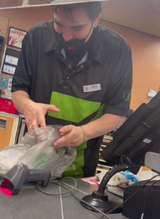 Chico en una tienda de conveniencia abriendo una bolsa con comida