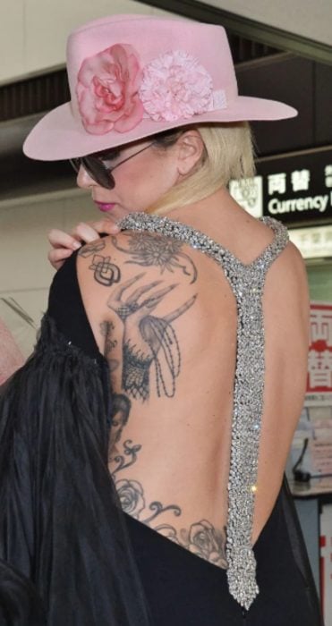 Lady Gaga mostrando su tatuaje de unas manos 