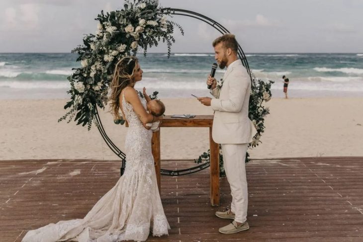 mujer amamantando a su bebé en el altar frente a su futuro esposo