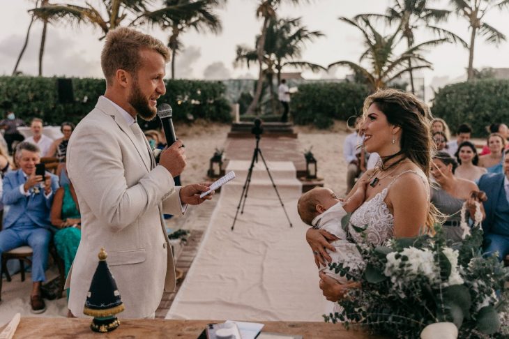 hombre dando sus votos matrimoniales mientras su esposa amamanta a su bebé 