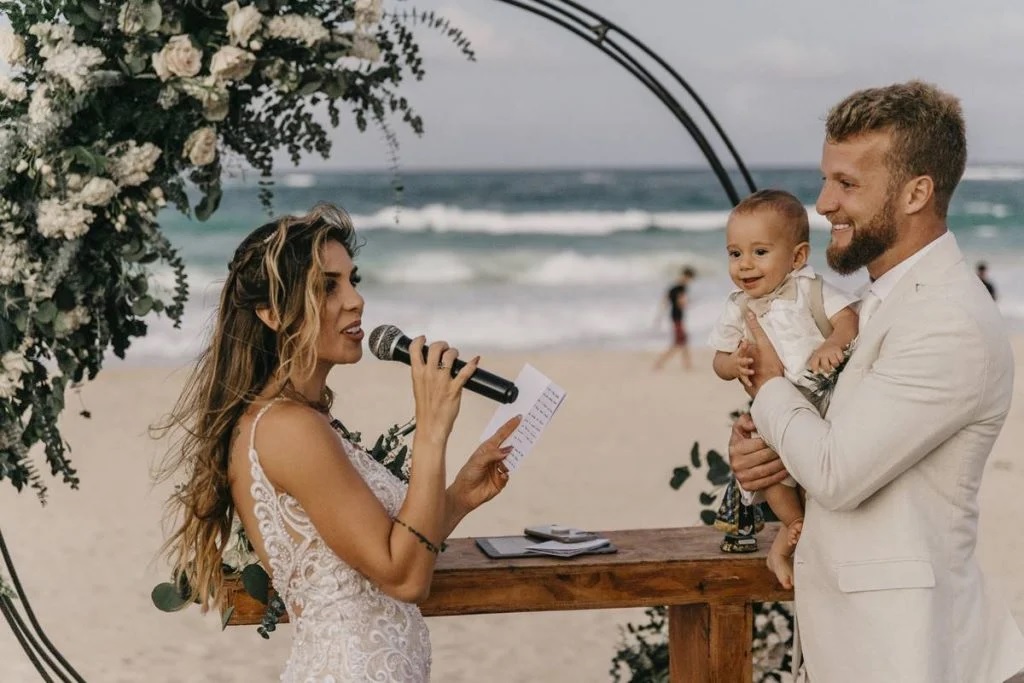 woman giving her wedding vows while her husband holds their baby 