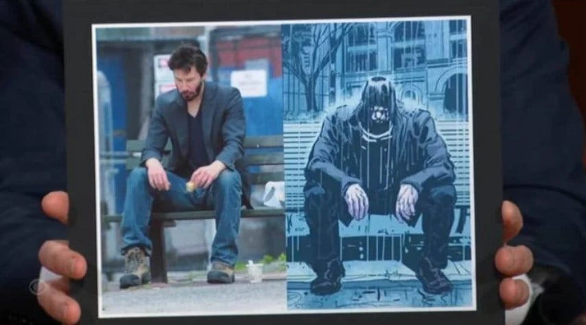 Keanu Reeves comiendo un bocadillo sentado en un parque