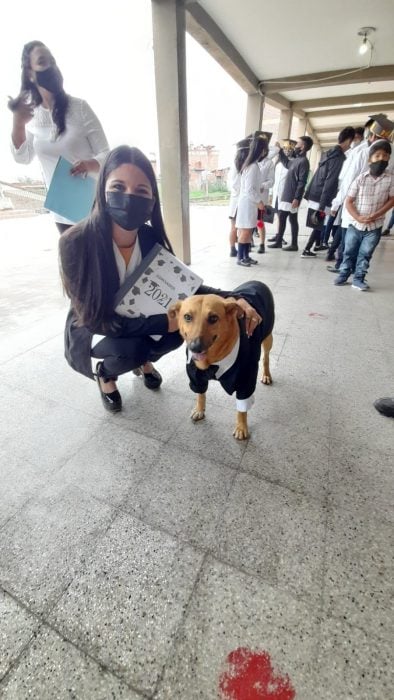 mujer en cunclillas posando a lado de un perro que recibió un reconocimiento en una escuela en Argentina 