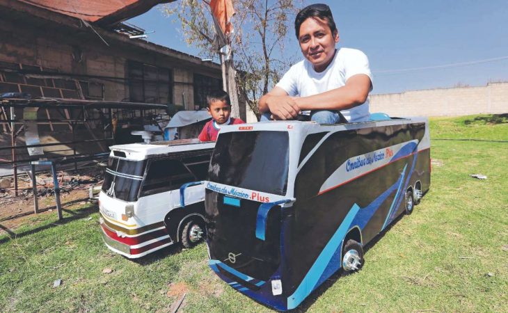 hombre en medio de dos camiones a escala para niños 