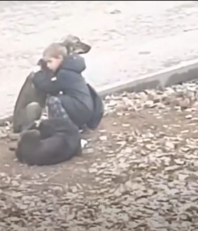 niño abrazando a dos perros callejeros