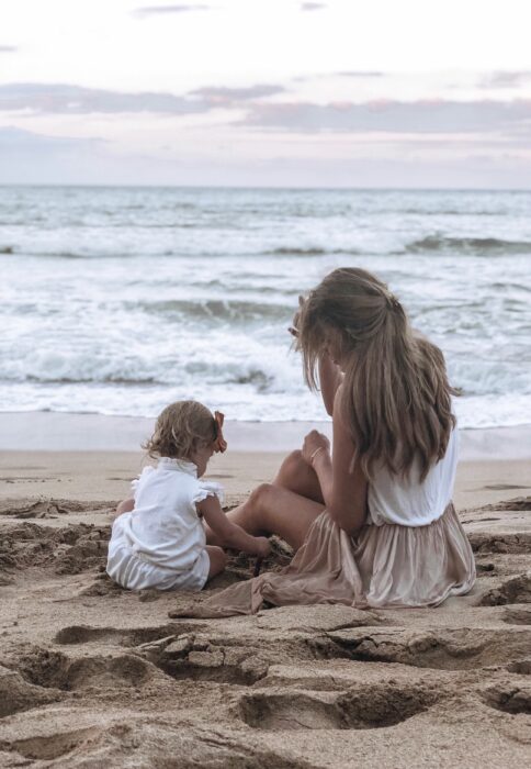 mamá jugando con su bebé en la arena