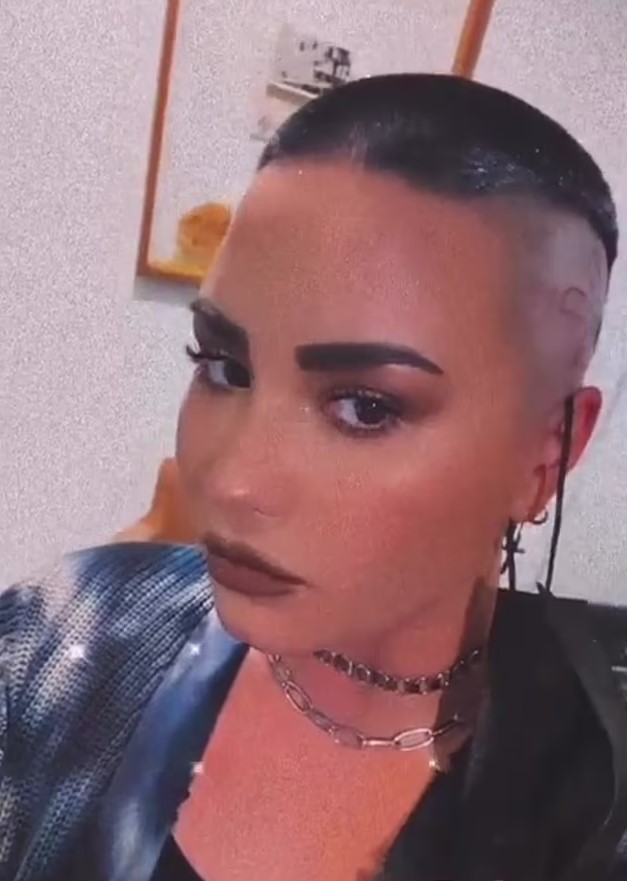 Demi Lovato mostrando su tatuaje en forma de araña