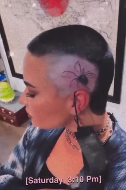 Demi Lovato mostrando su tatuaje en forma de araña 
