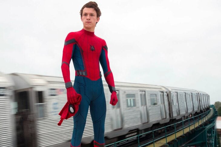 Fotografía de Tom Holland como el hombre araña sobre unas vías del tren 