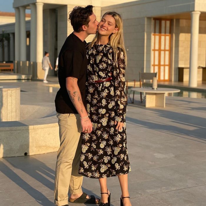 Brooklyn Beckham posando mientras le da un beso en la mejilla a la modelo Nicola Peltz