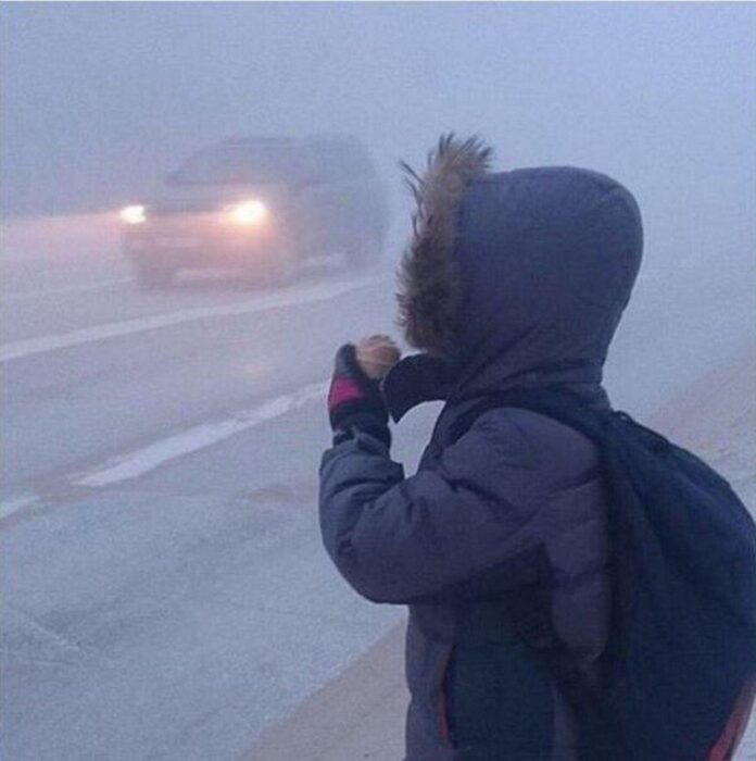 niño comiendo nieve en una tormenta invernal