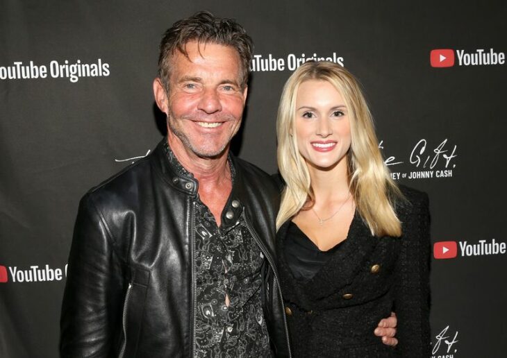 Dennis Quaid and Laura Savoie embracing each other posing for a photo on a red carpet 