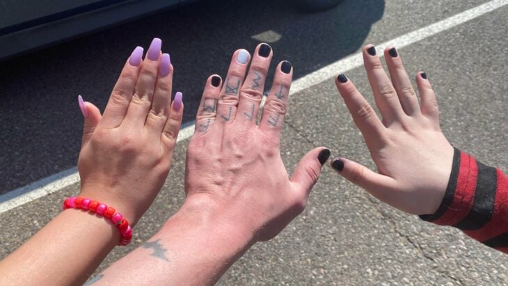 imagen de las manos de dos niñas con la de su papá mostrando las uñas pintadas 
