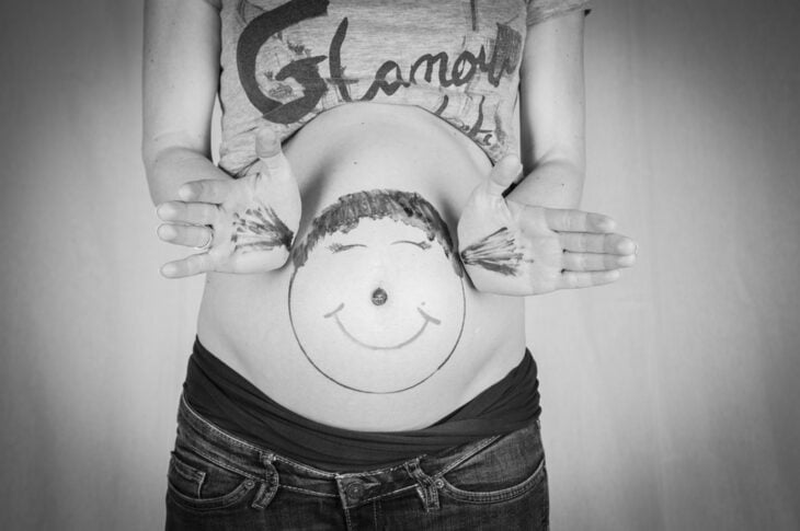 panza de una chica embarazada con un dibujo en su barriga 
