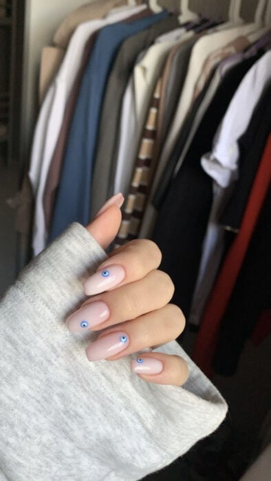 foto de una mano mostrando las uñas frente a un guarda ropa 