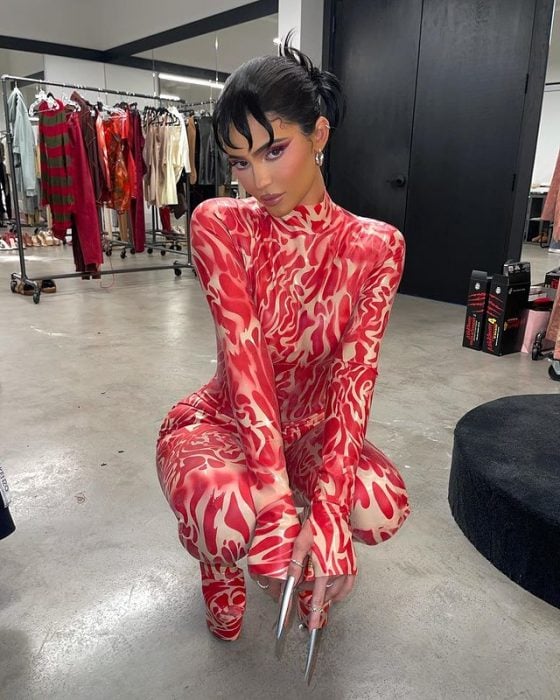 Kylie Jenner posando para una fotografía usando un outfit de color rojo 