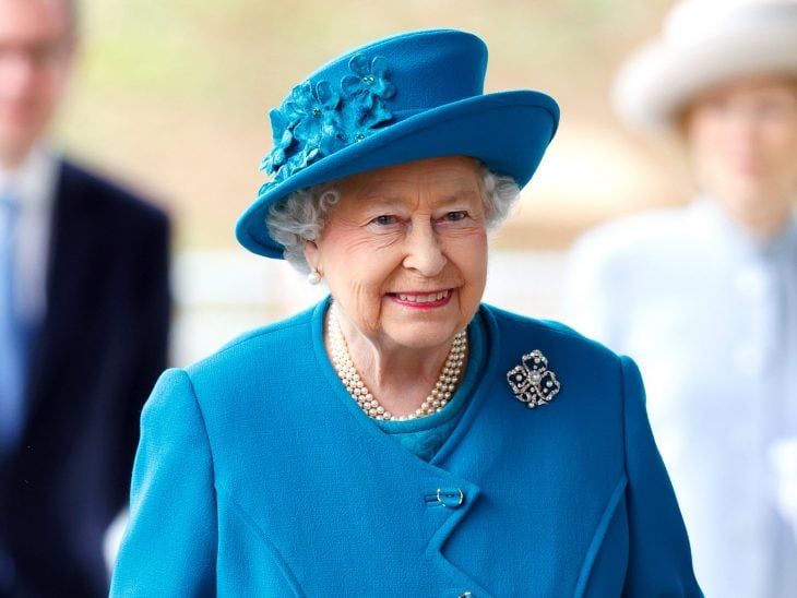 Fotografía de la Reina Isabell ll en un atuendo en color azul 
