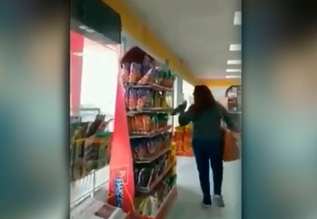 Mujer tomando unas papas fritas de un estante en una tienda 