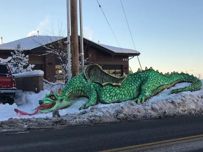 snow sculpture in the form of a giant dragon in green color 