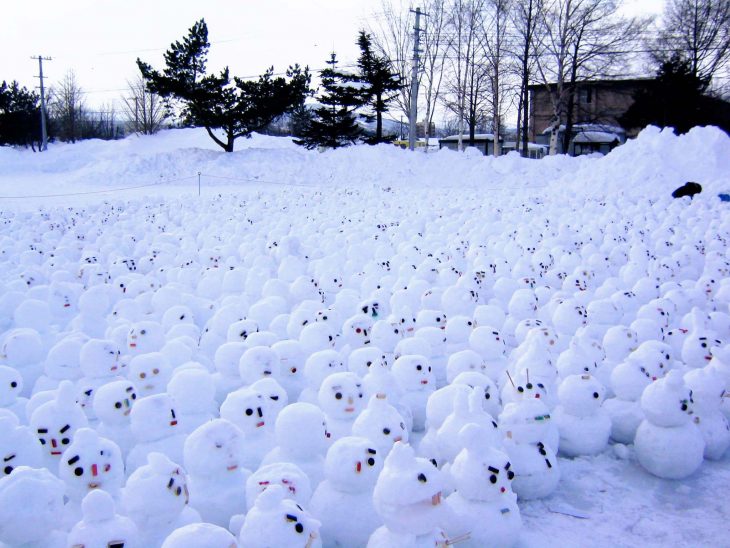 muchas figuras de muñequitos de nieve en un patio 
