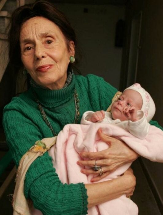 Mujer de 83 años cargando a un bebé 