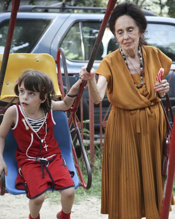 83-year-old woman playing with her daughter on swings 