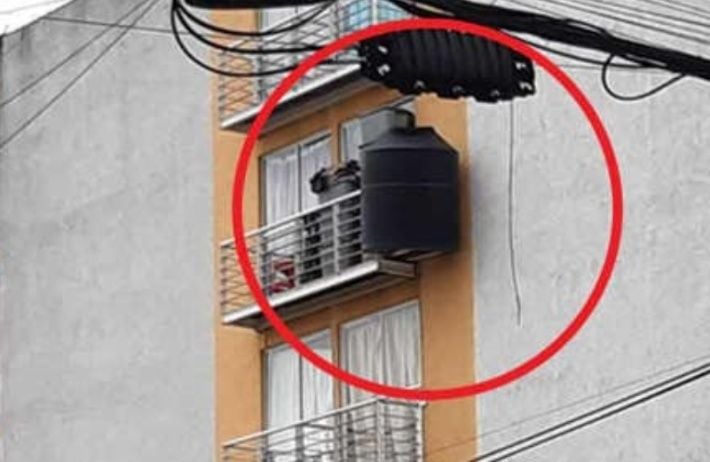 Denuncia en facebook de mujer que cuelga su tinaco con dos tablas en un balcón