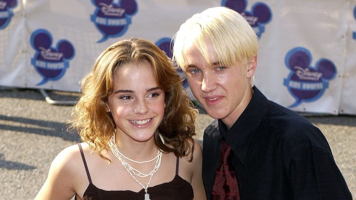 Tom Felton y Emma Watson en la alfombra roja de una película