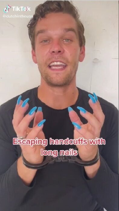 captura de vídeo de un hombre con las manos esposadas usando uñas acrílicas