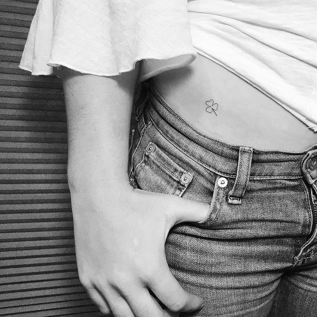 Girl showing a tattoo on her waist 