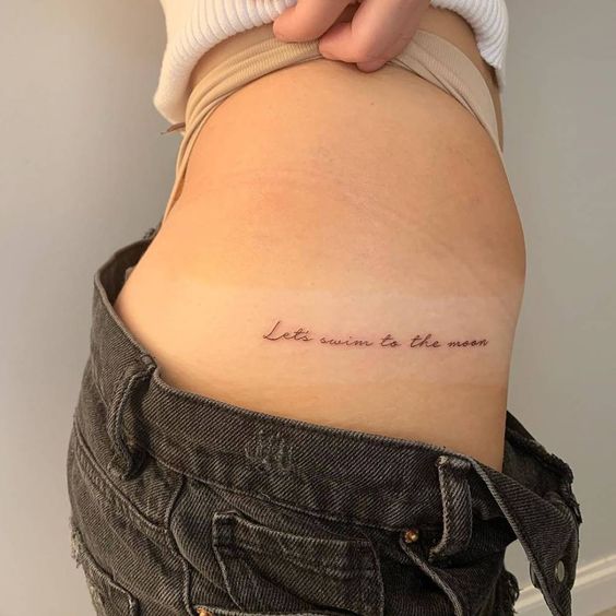 Girl showing a tattoo on her waist 