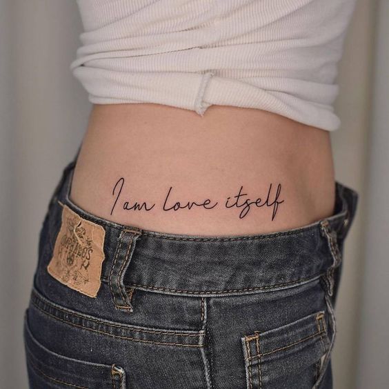 Girl showing a tattoo on her waist 