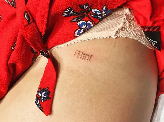 Girl showing a tattoo on her waist 