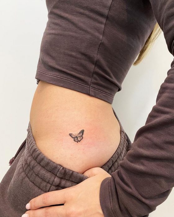 Girl showing a tattoo on her waist 