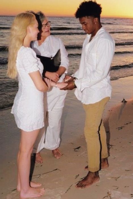 Pareja de novios el día de su boda caminando por la playa 