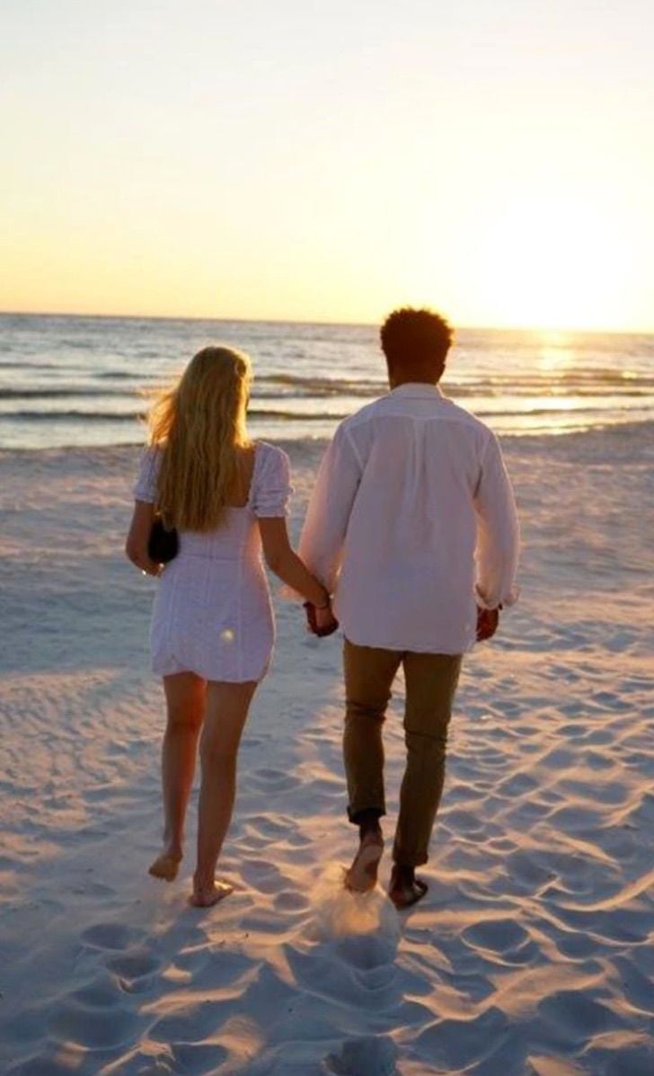 Pareja de novios el día de su boda caminando por la playa 
