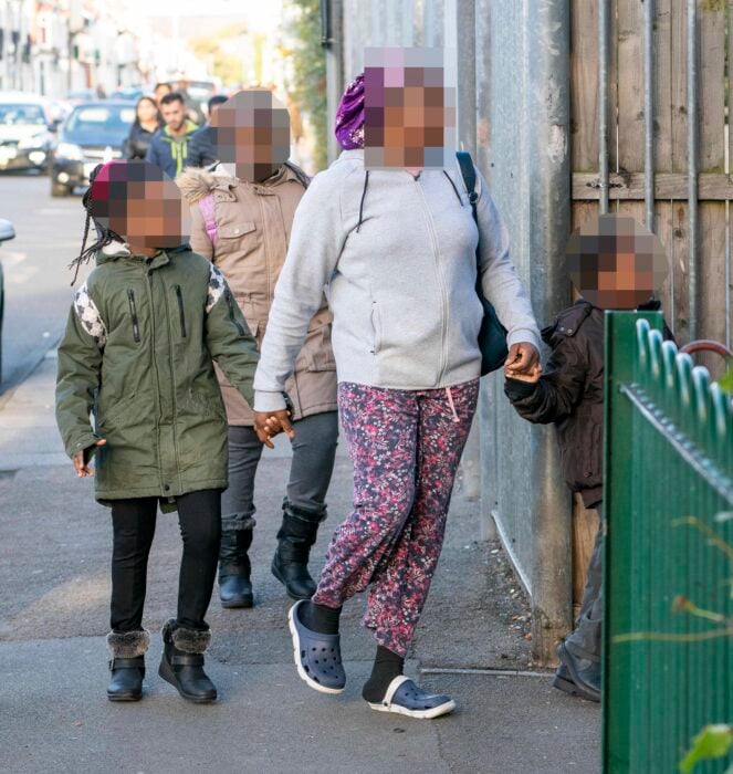 foto de una madre llevando a sus hijos en pijama a la escuela