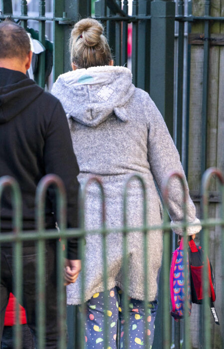 photo of a woman from behind taking her children to school 