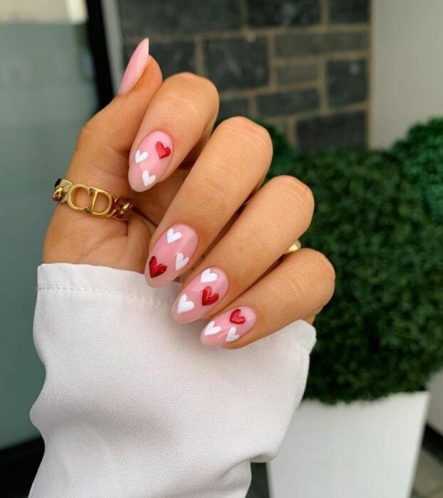 uñas cortas con corazones blancos y rojos