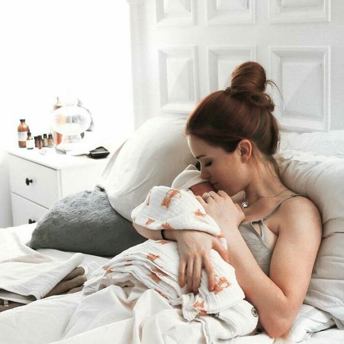 mamá abrazando a su bebé en cama