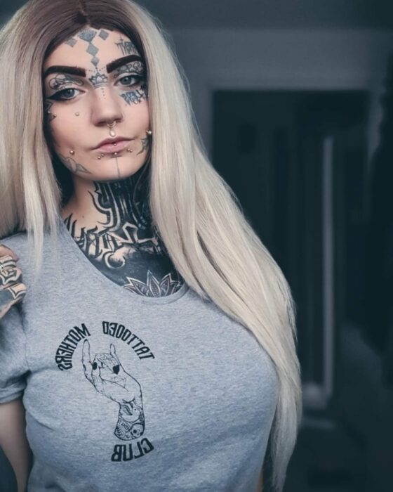 photo of a woman showing her tattoos on her face 