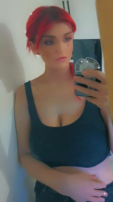 selfie en el espejo de una mujer de cabello rojo 
