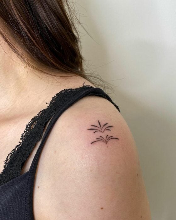 tatuaje de unas ramas en el hombro de una chica 