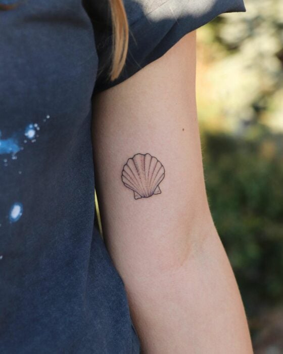 tatuaje de una concha de mar en el brazo de una chica 