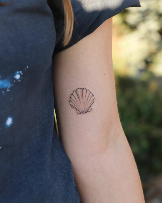 tattoo of a sea shell on the arm of a girl 