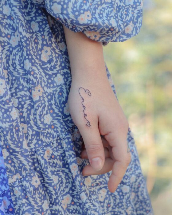 tattoo of the name of a person on the finger of a girl 