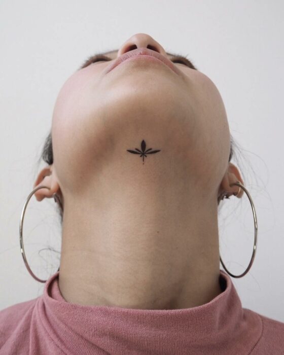 face of a woman with a branch tattoo under her chin