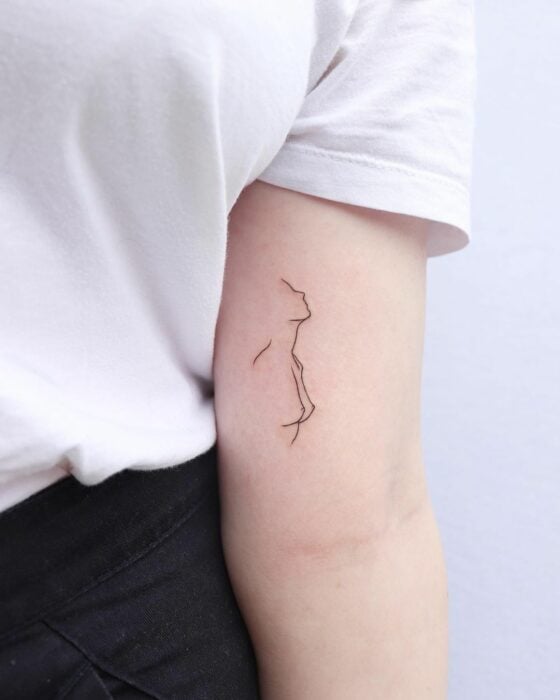 tatuaje de la silueta de una mujer sobre el antebrazo de una chica 